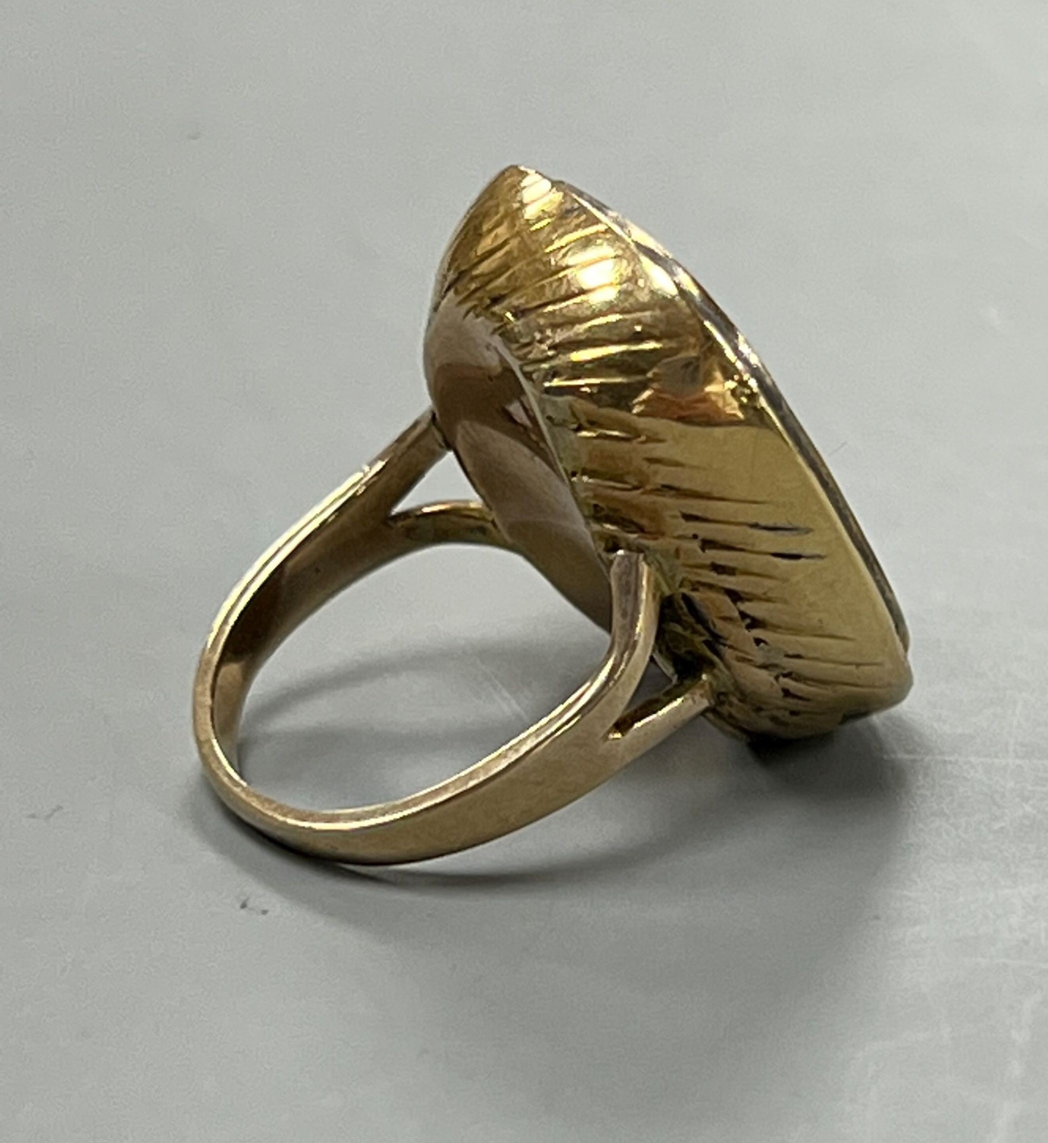 A 19th century yellow metal and intaglio yellow paste set ring, carved with 'The Thinker' after Rodin, size I, gross 8.7 grams.